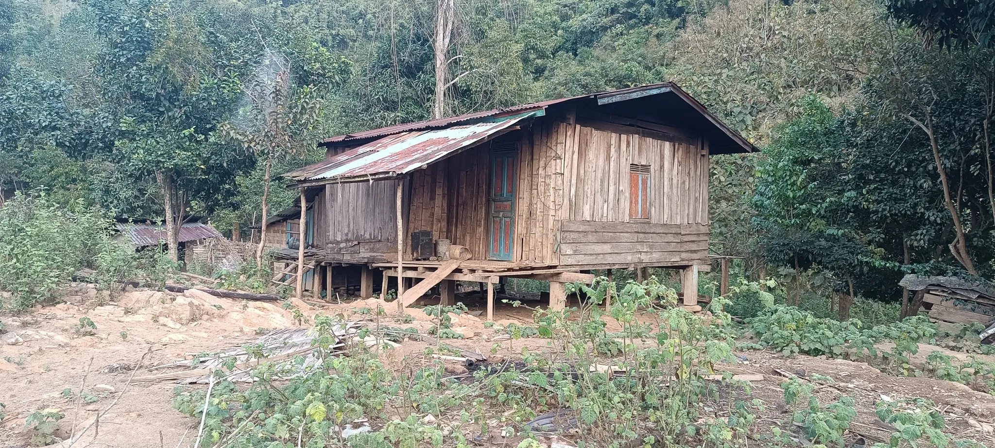 A deserted wooden house on stilts with jungle encroaching at an abandoned settlement along the Nam Ou river in Laos