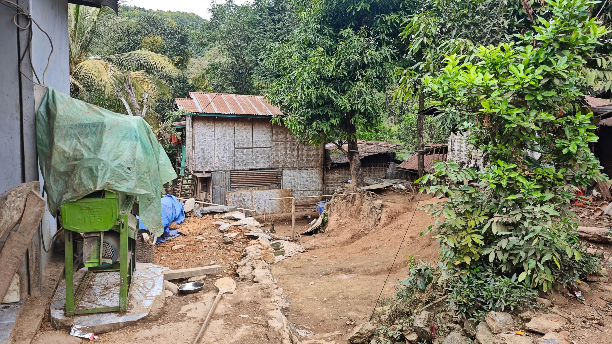 Bamboo and corrugated-iron houses on a hillside with tropical vegetation in Ban Haddean village near the Nam Ou river