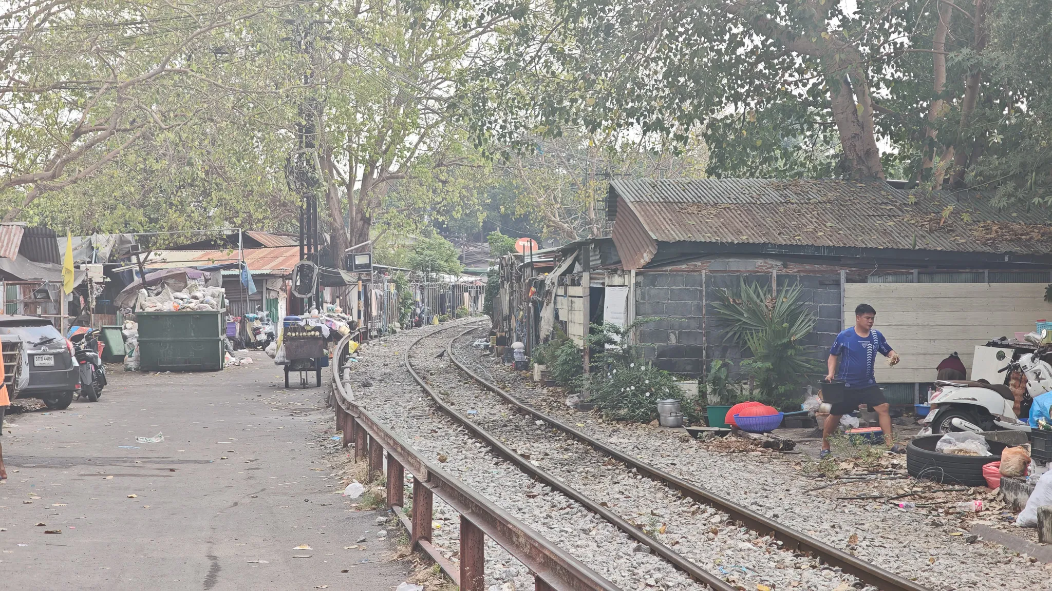Trackside community along the Bangkok railway line with houses built close to the curved train tracks