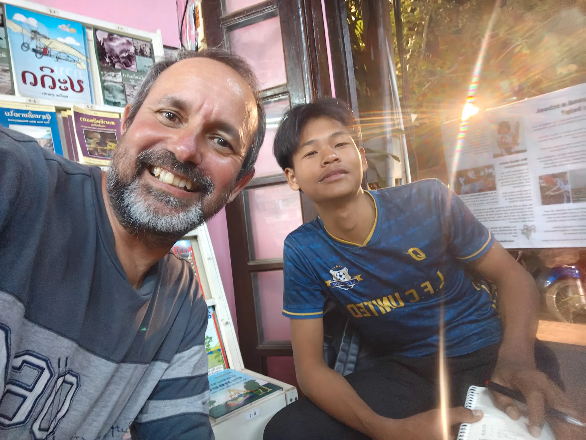 Volunteer practising English with a young Lao student at the Big Brother Mouse reading room in Luang Prabang