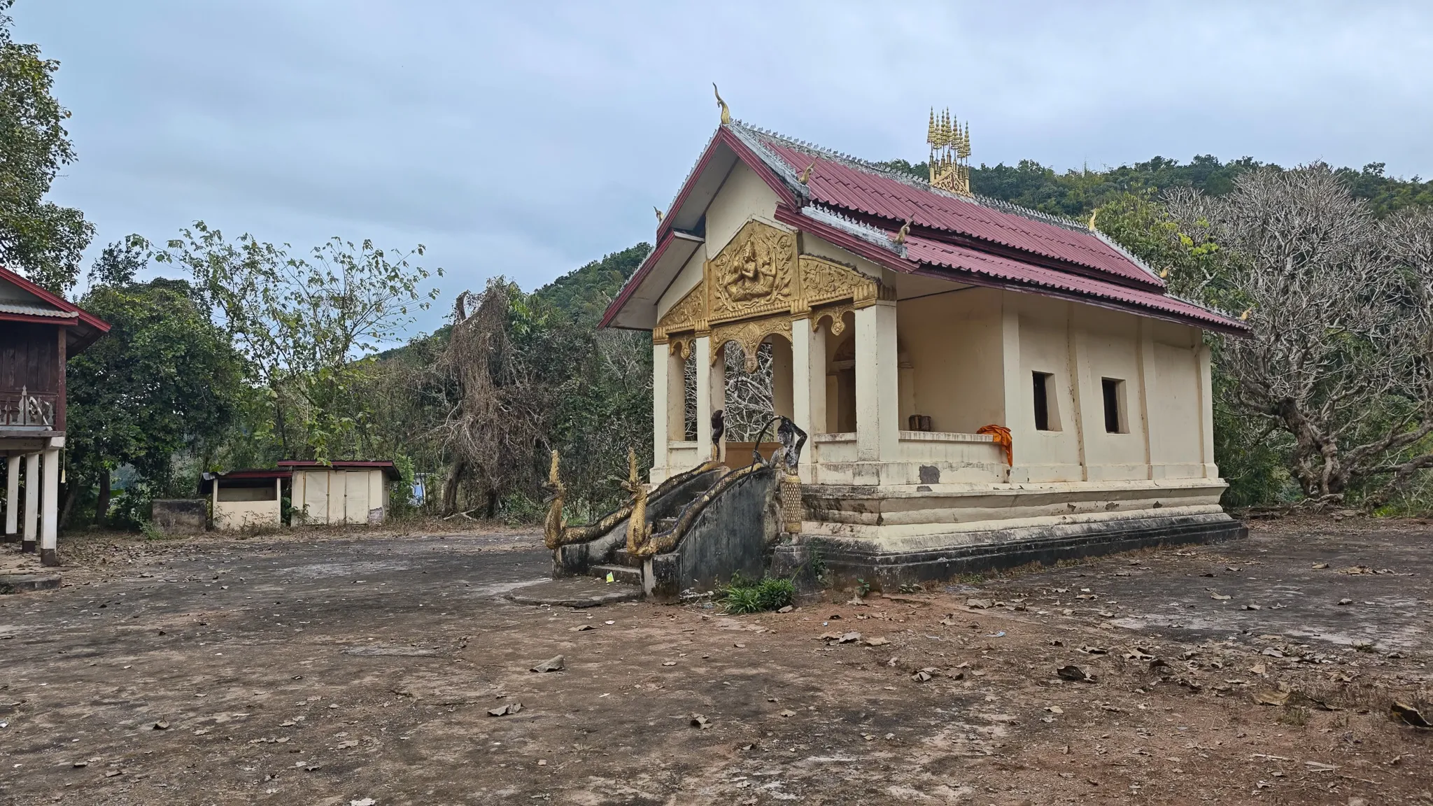 Small Buddhist temple with gold carved pediment and naga staircase at Ban Haddean village near the Nam Ou river