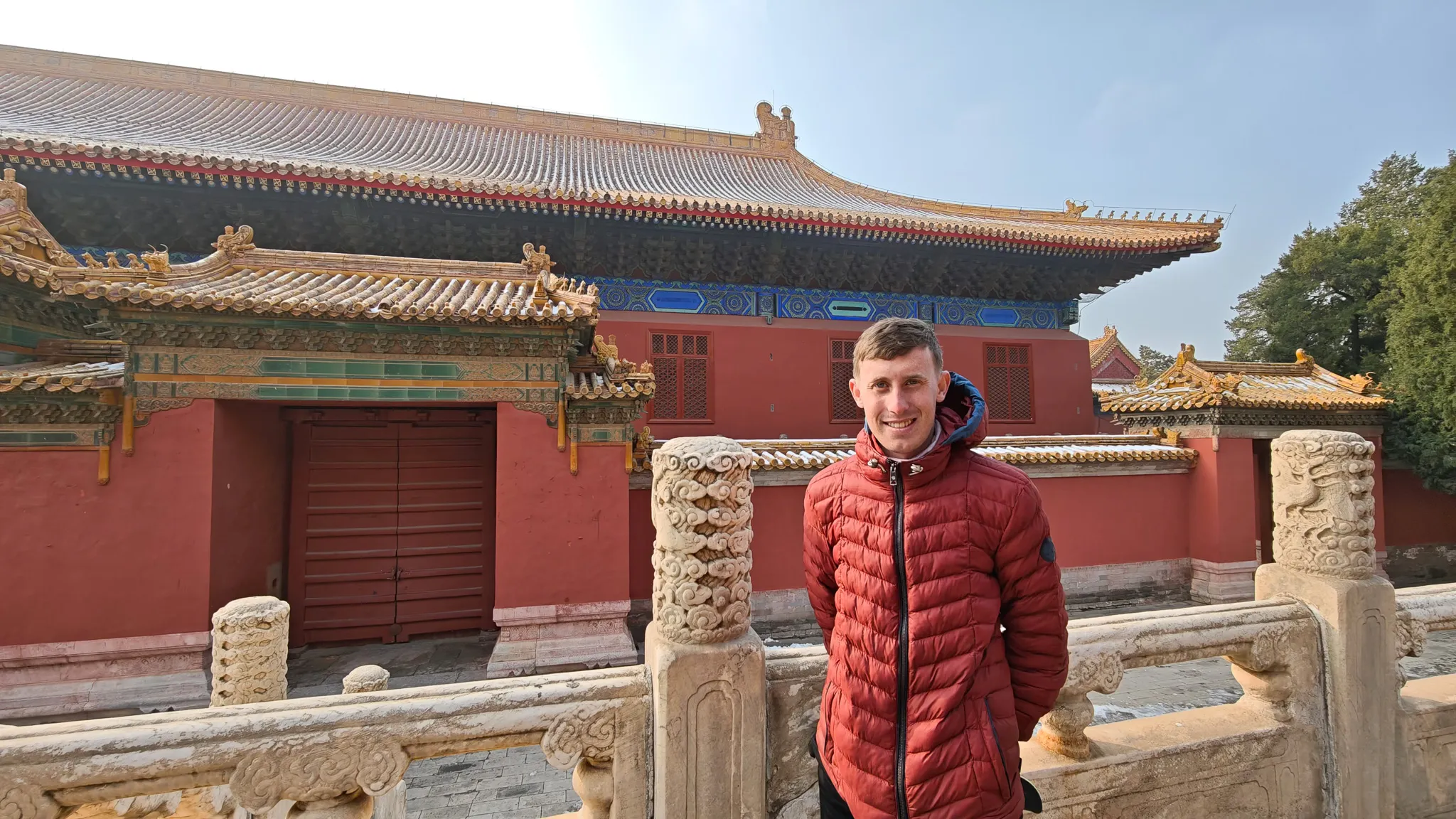 Selfie in front of a hall inside the Forbidden City in Beijing with ornate tiled roofs and marble balustrades