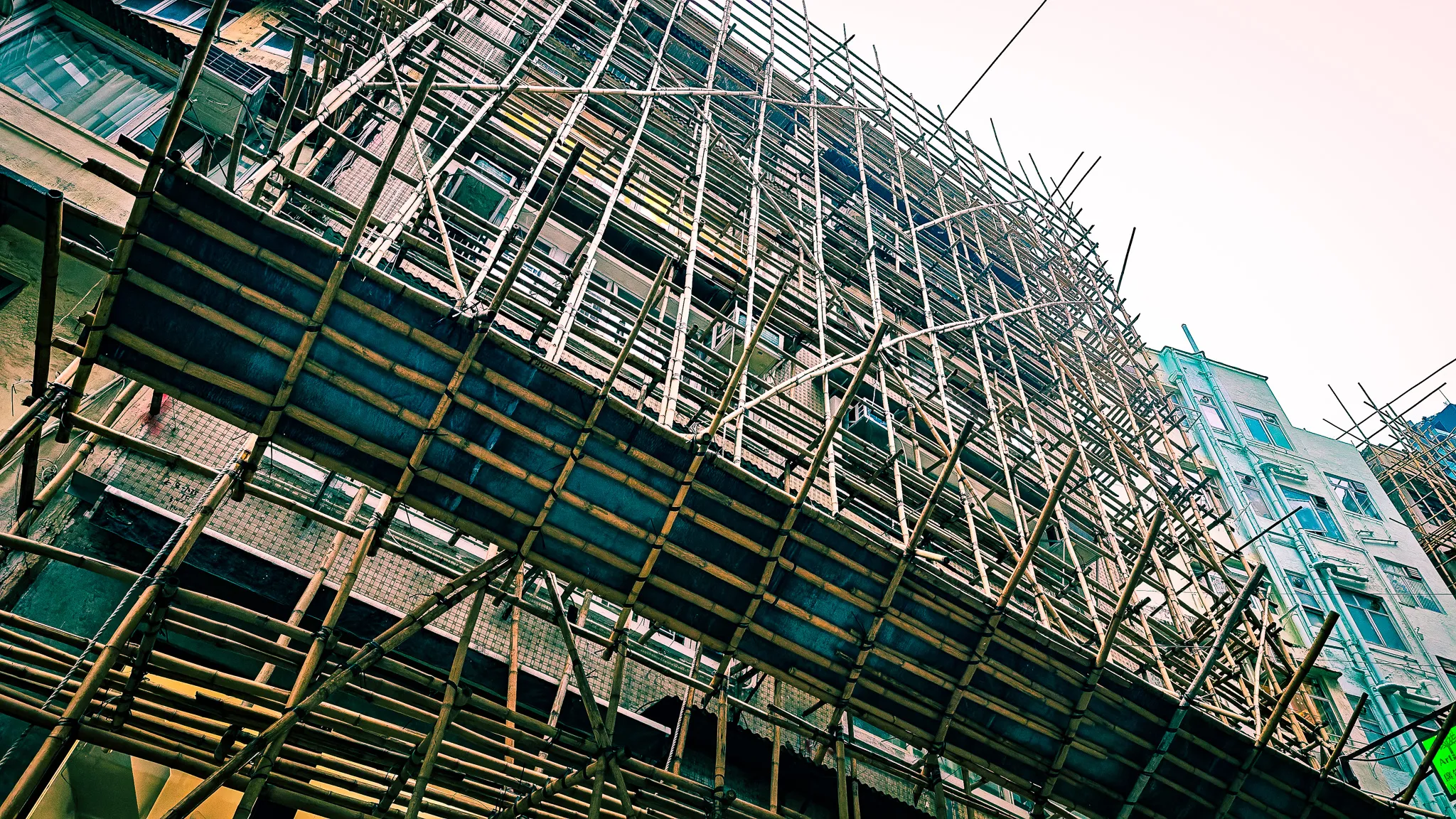 Traditional bamboo scaffolding covering a building under renovation in Hong Kong, viewed from below