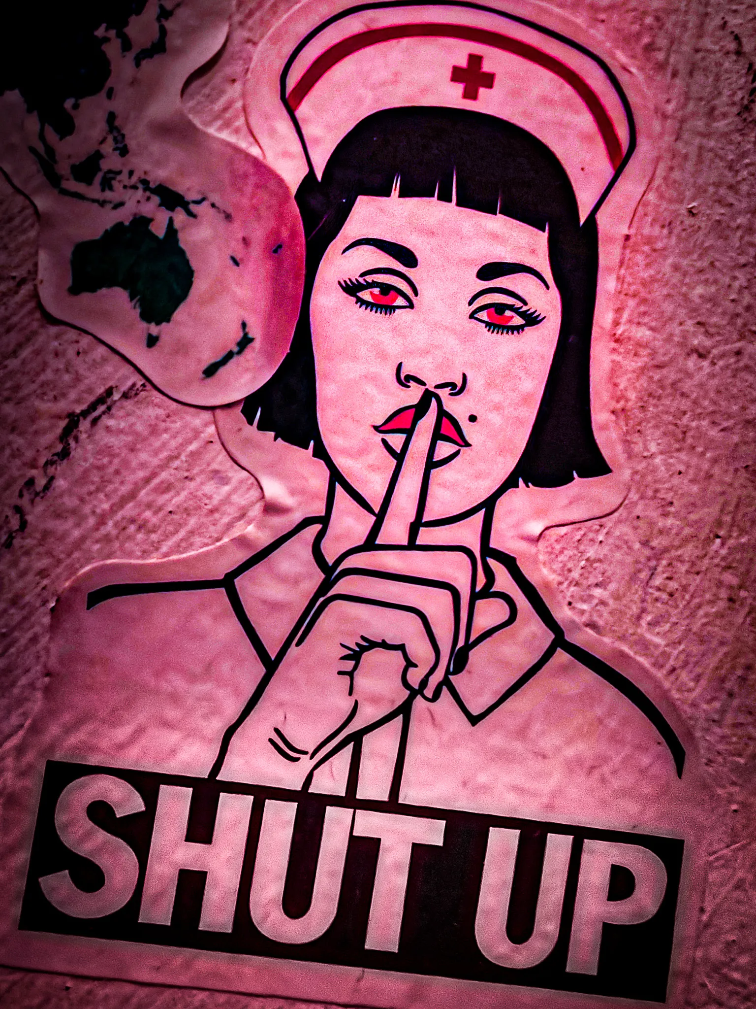 Pink-toned street art poster of a nurse with finger to lips and Shut Up text on a Hong Kong bar wall