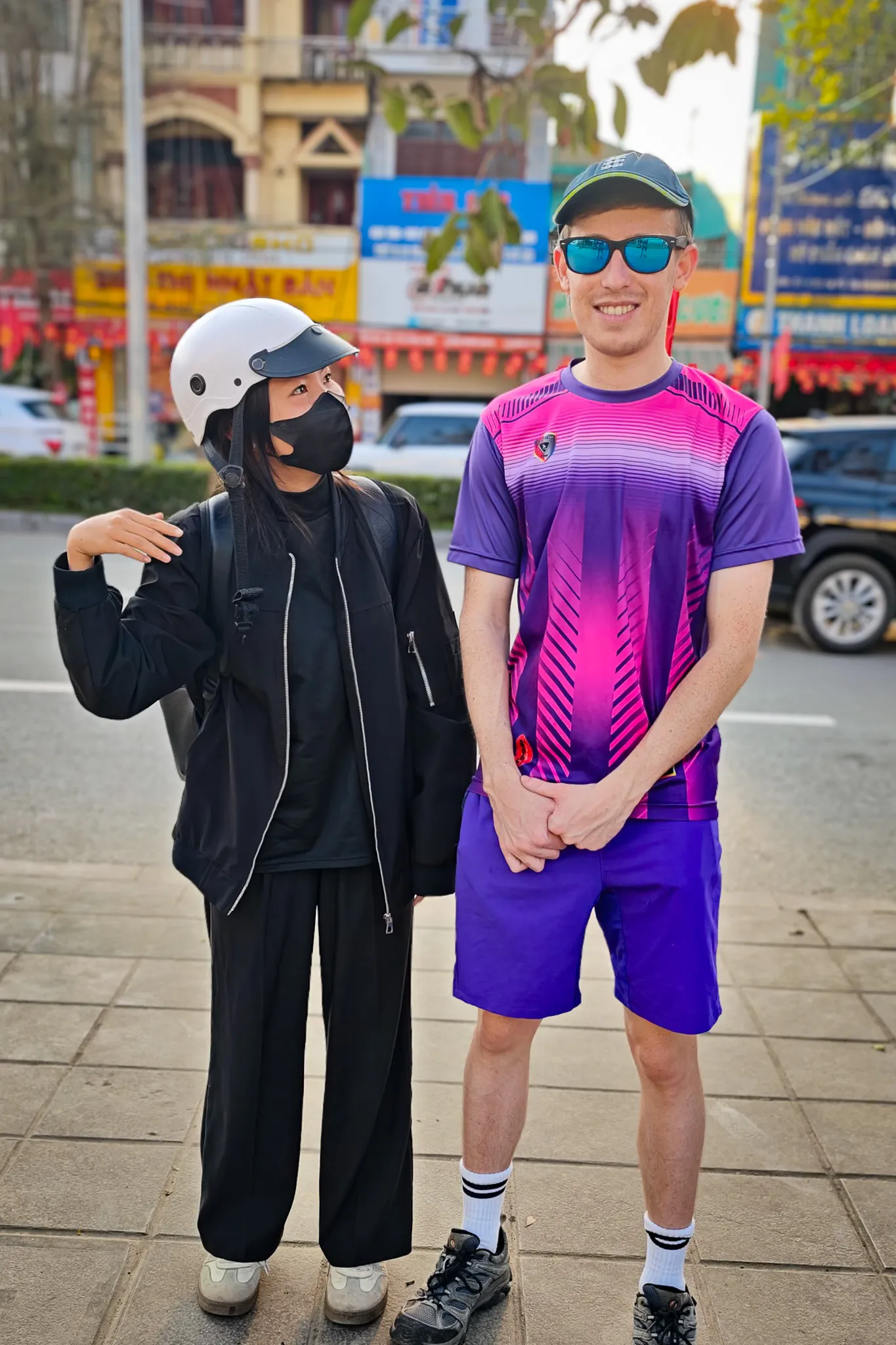 Meeting a local friend on the streets of Dien Bien Phu — Vietnamese town with colourful shopfronts and red banners