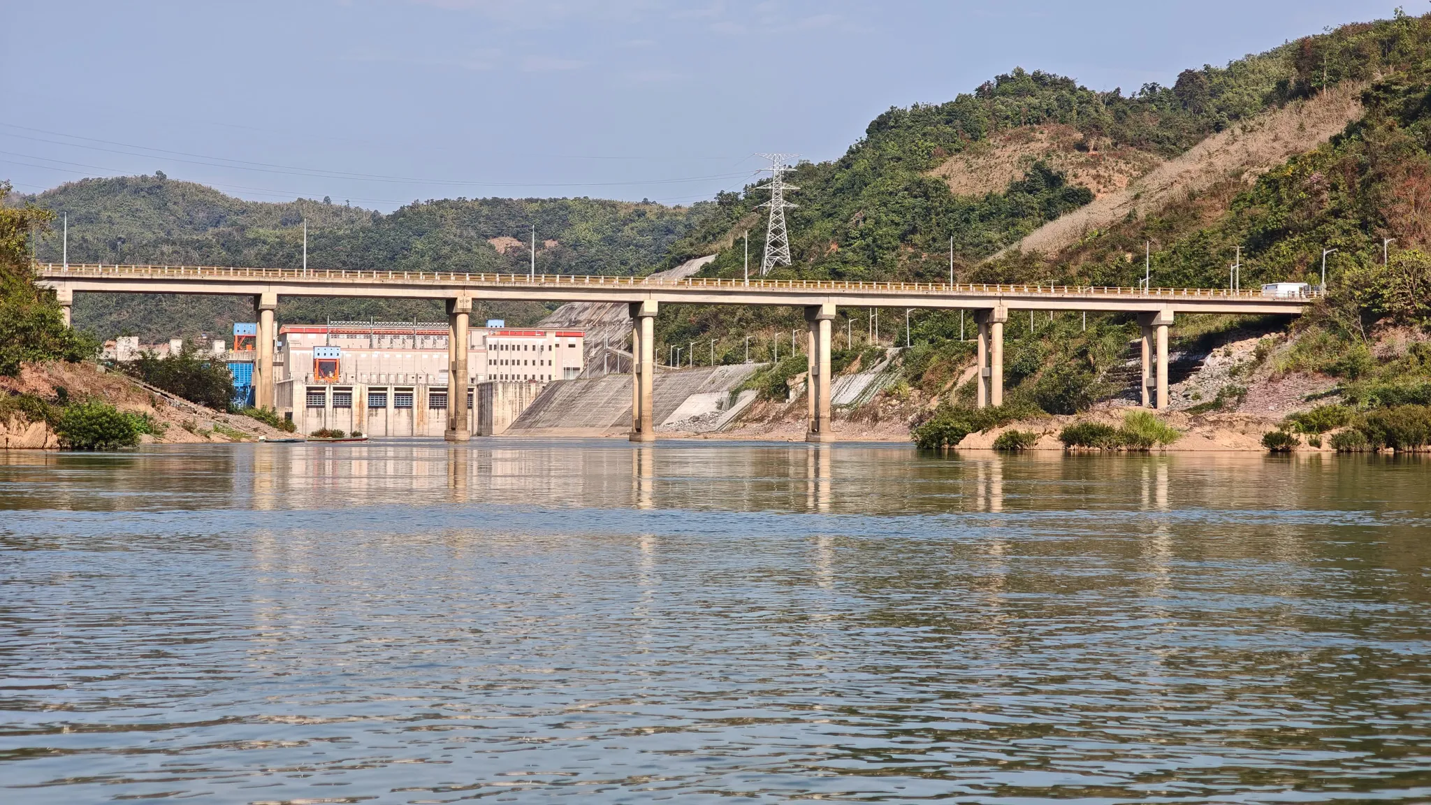 Close-up of the Nam Ou hydroelectric dam and road bridge with spillway and power station visible
