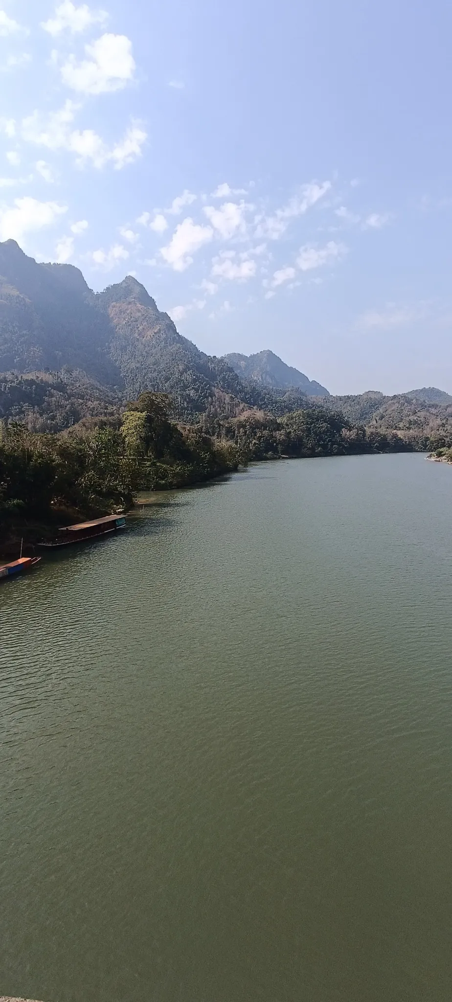 Panoramic view from Nong Khiaw bridge showing the Nam Ou river, longboats, and karst mountains