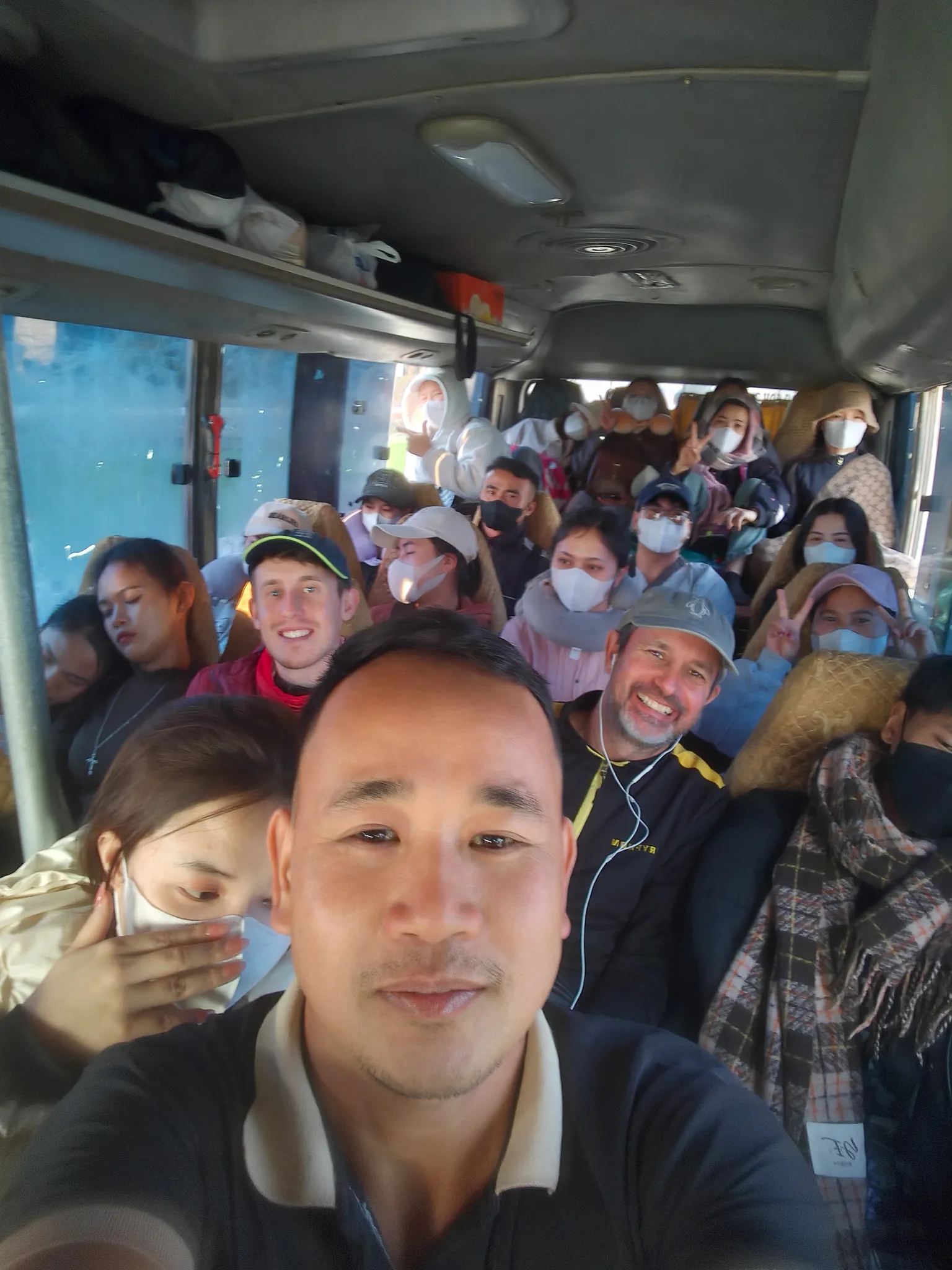 Interior of the packed Dien Bien to Phongsaly minibus showing dozens of passengers filling every seat and aisle