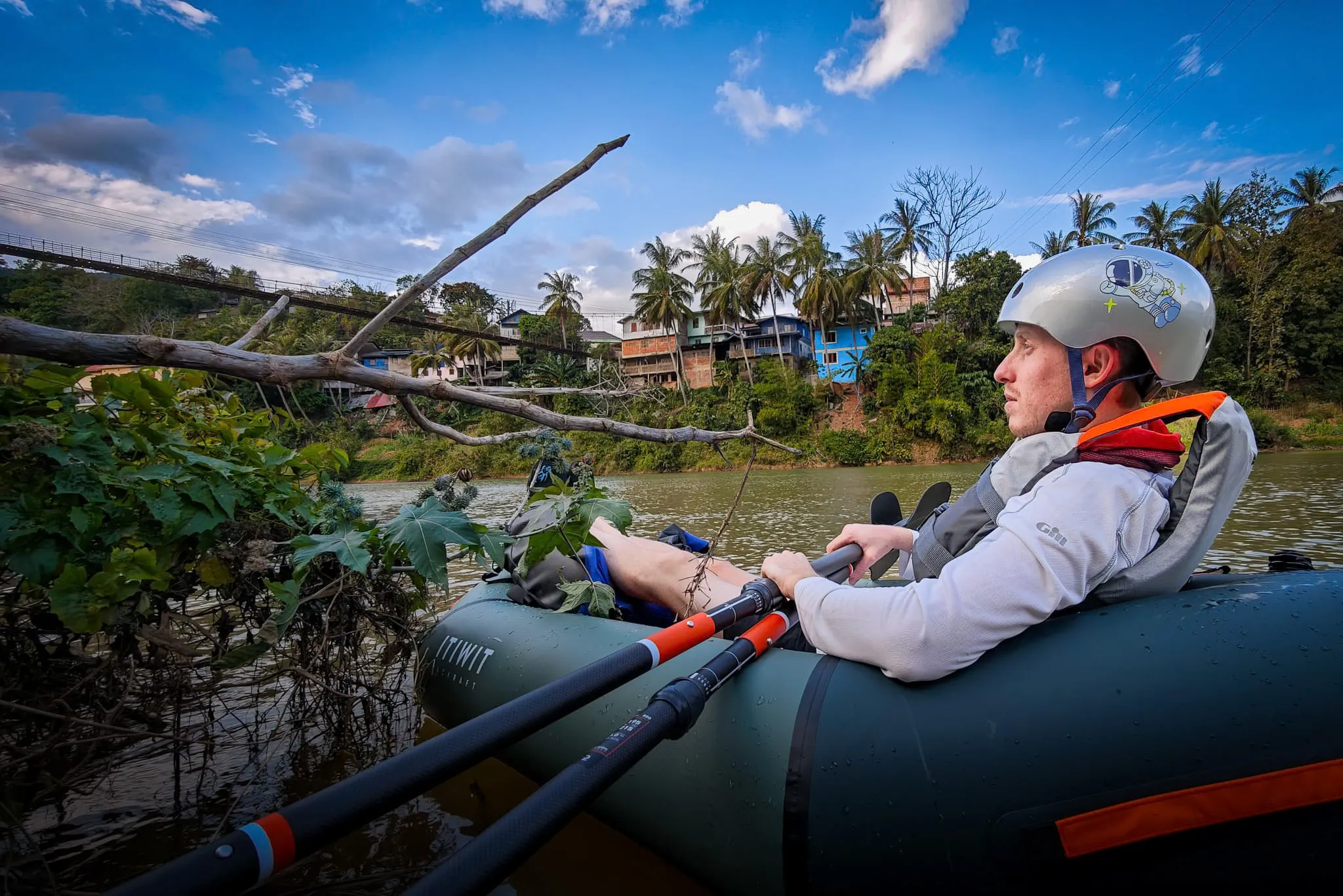 Close-up of packrafter relaxing in an Itiwit packraft on the Nam Ou river near the suspension bridge in Muang Khua
