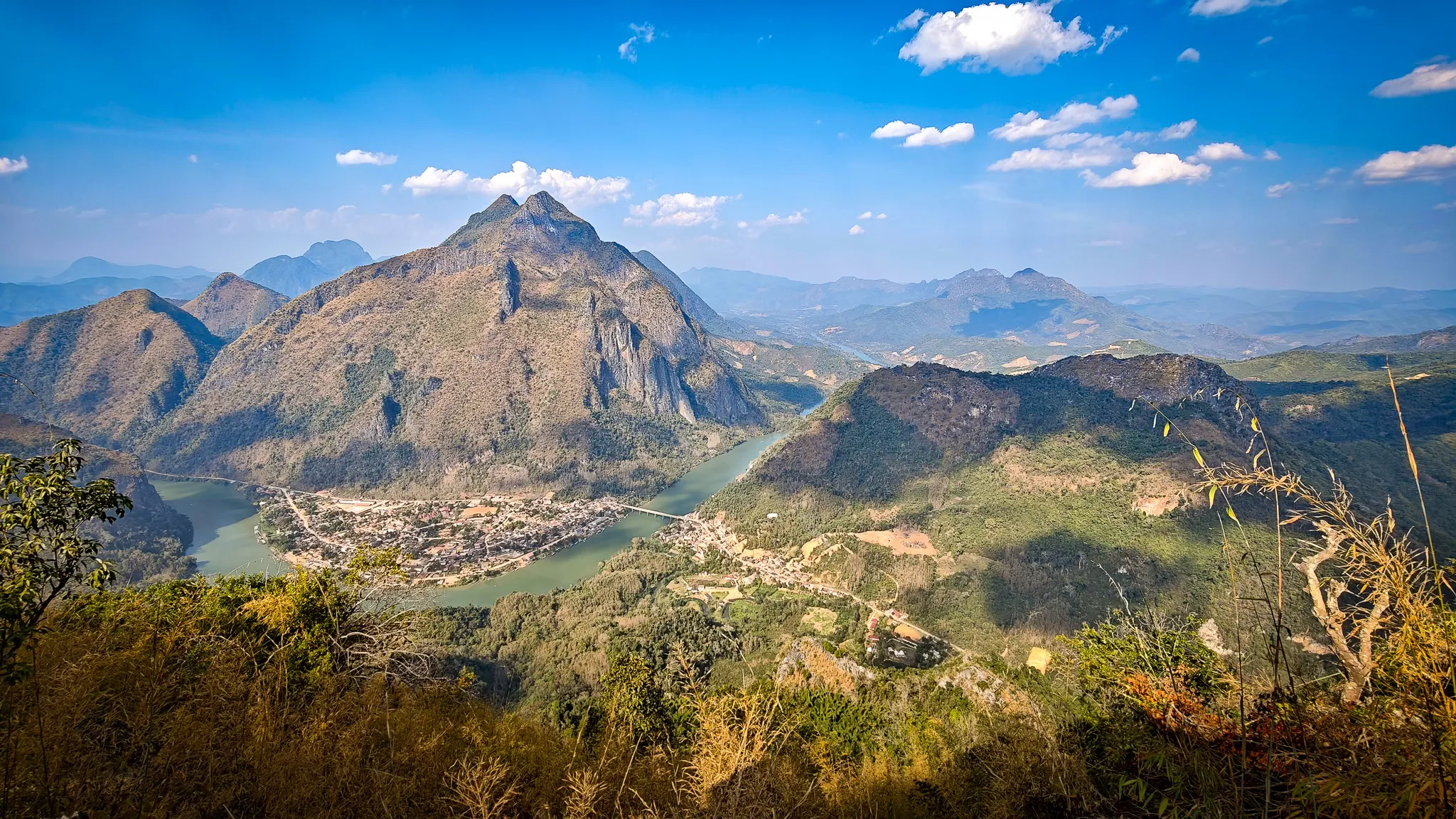 Panoramic view from Pha Kew Lom viewpoint looking across the valley toward Nong Khiaw and surrounding mountains