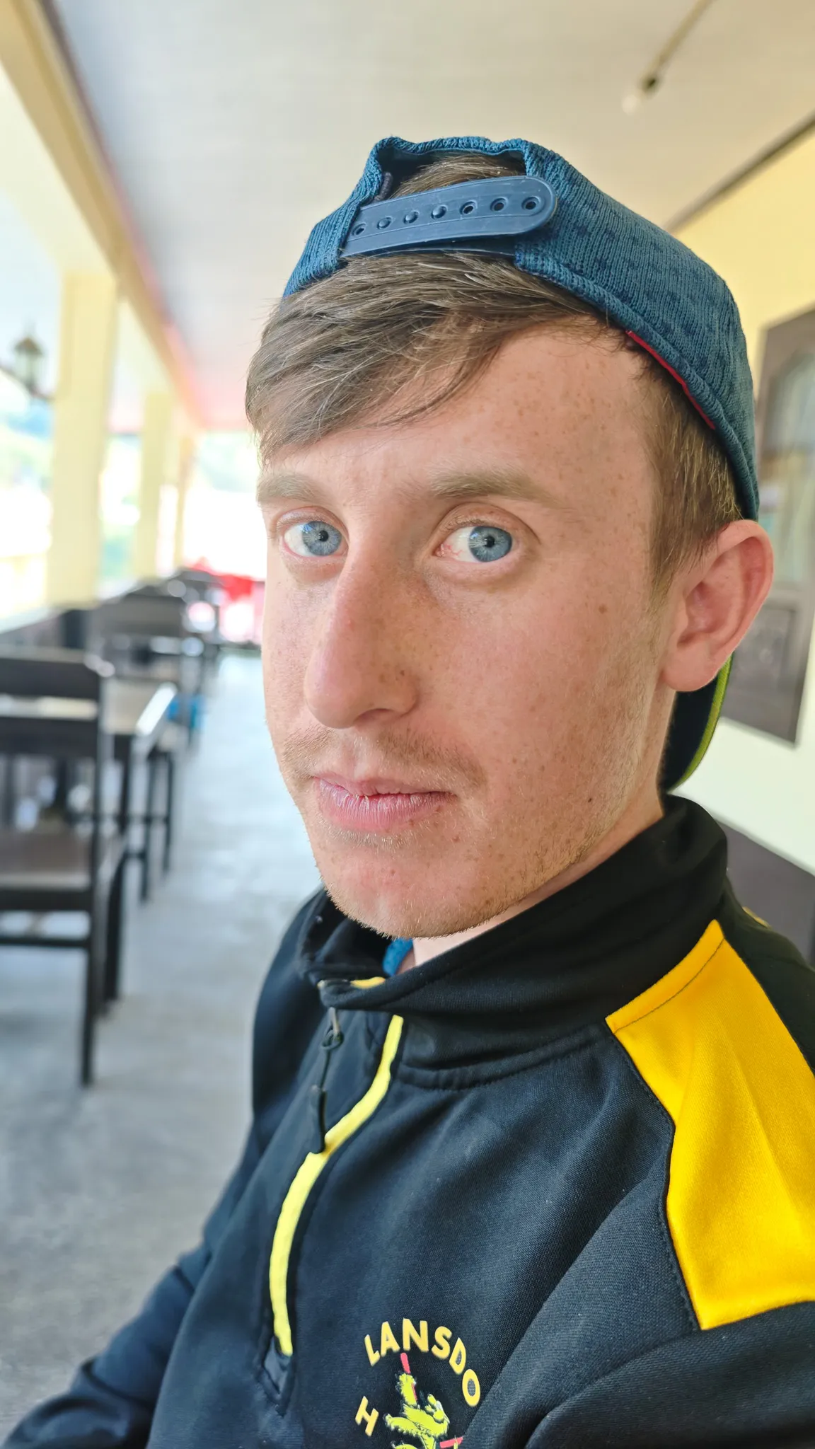 Selfie of a traveller wearing a backwards cap at a restaurant in Nong Khiaw