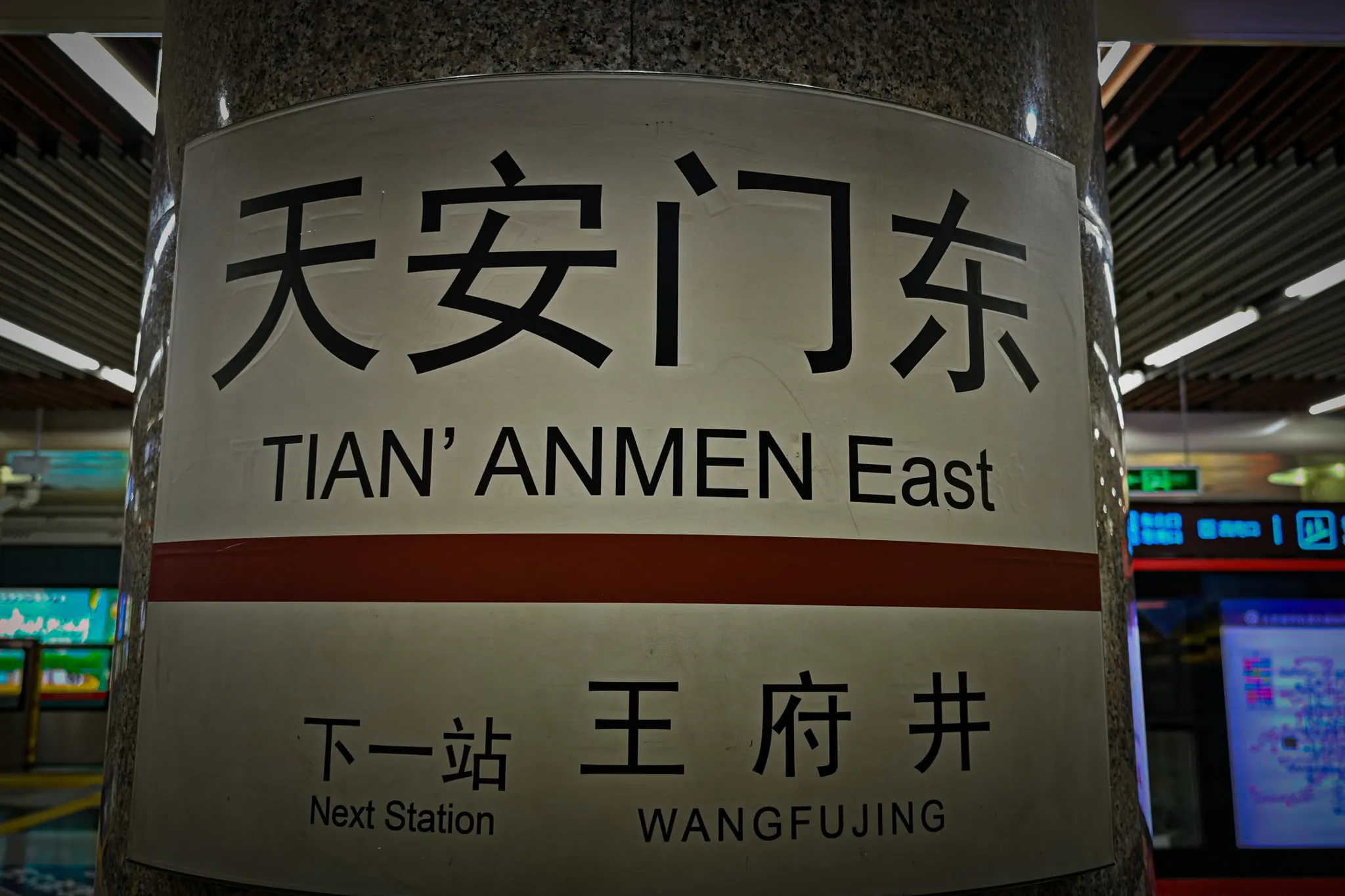 Tiananmen East metro station pillar sign in Chinese and English with next station Wangfujing displayed below