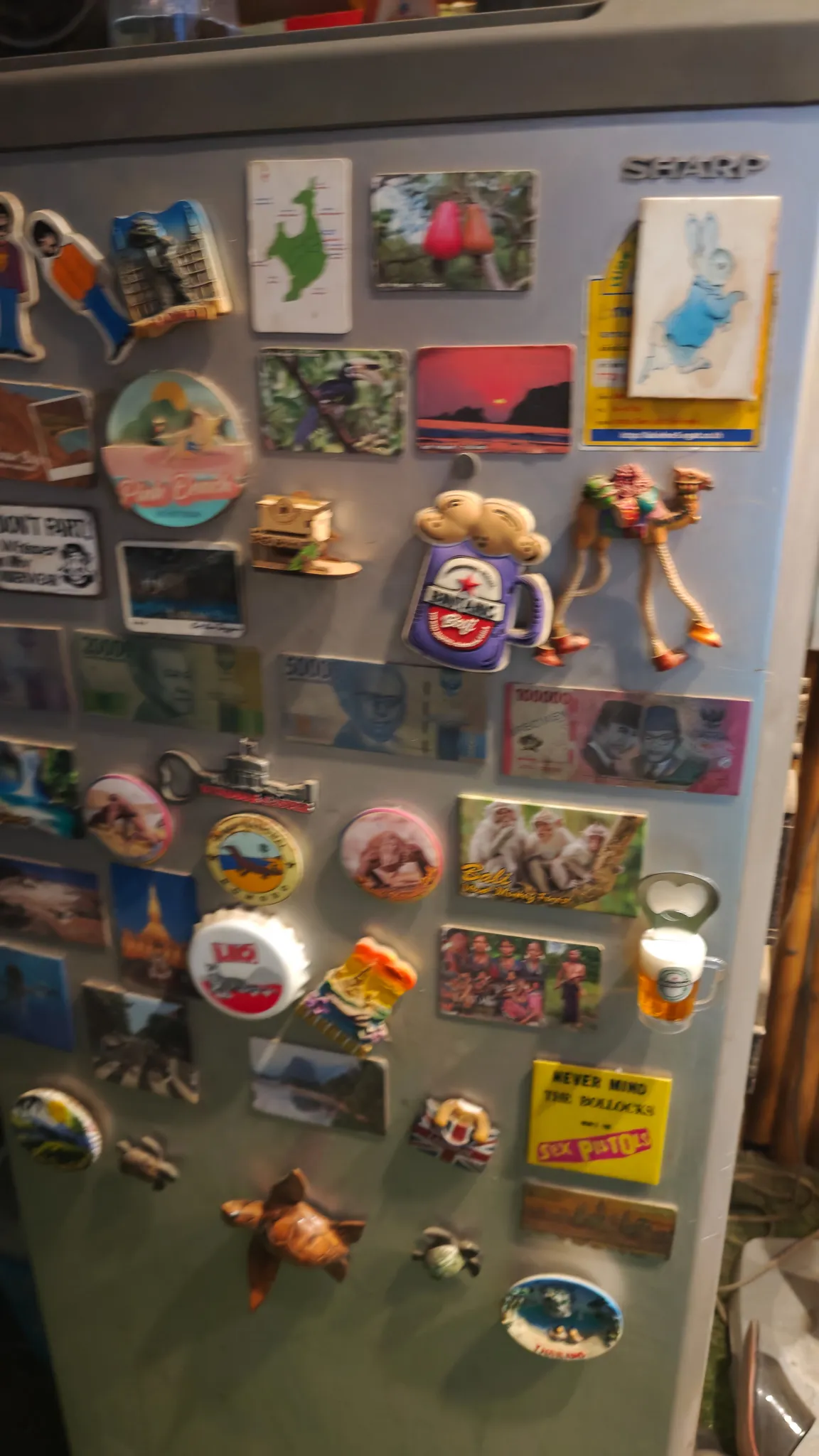 Fridge covered in travel fridge magnets from around the world at a bar in Vang Vieng