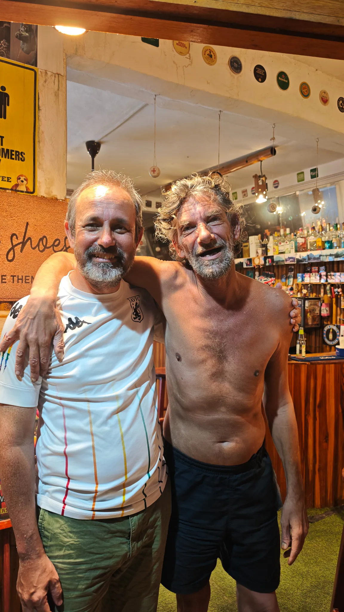 Selfie with the English bar owner at a secret dive bar in Vang Vieng with bottles and memorabilia behind
