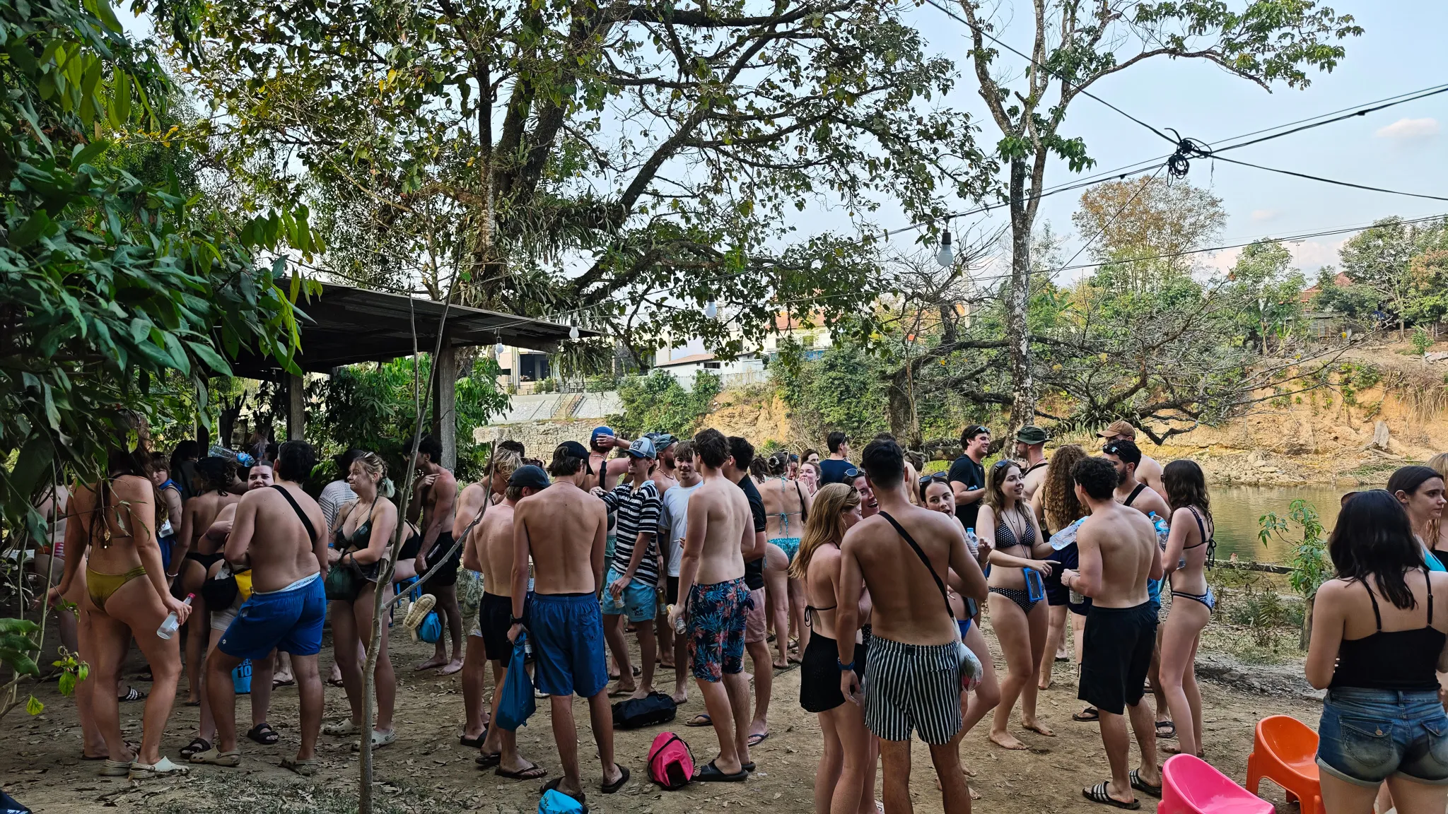 Crowd of backpackers at a riverside tubing bar party along the Nam Song River in Vang Vieng