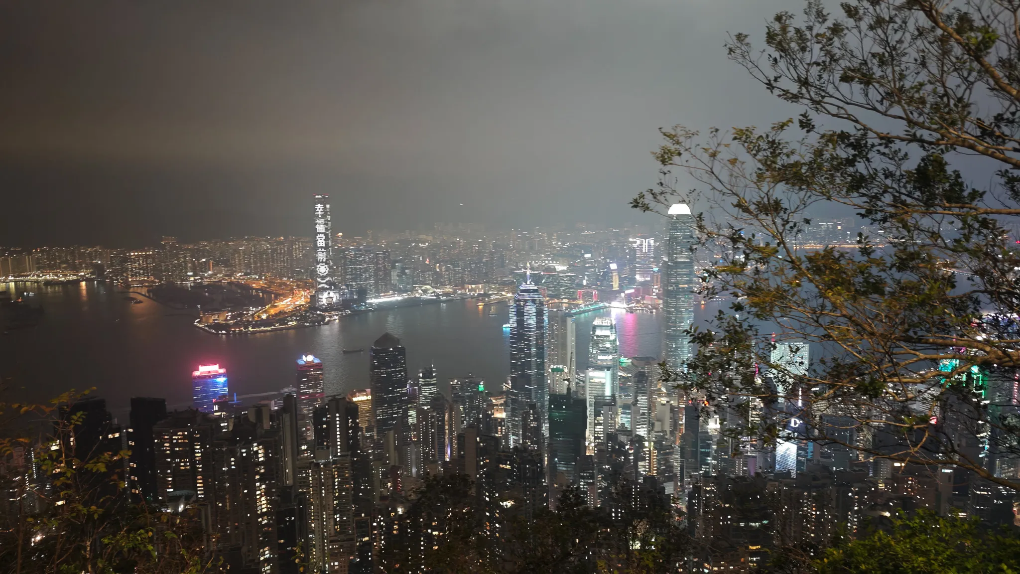 Night view from Victoria Peak showing Hong Kong harbour, ICC tower in Kowloon and the illuminated skyline