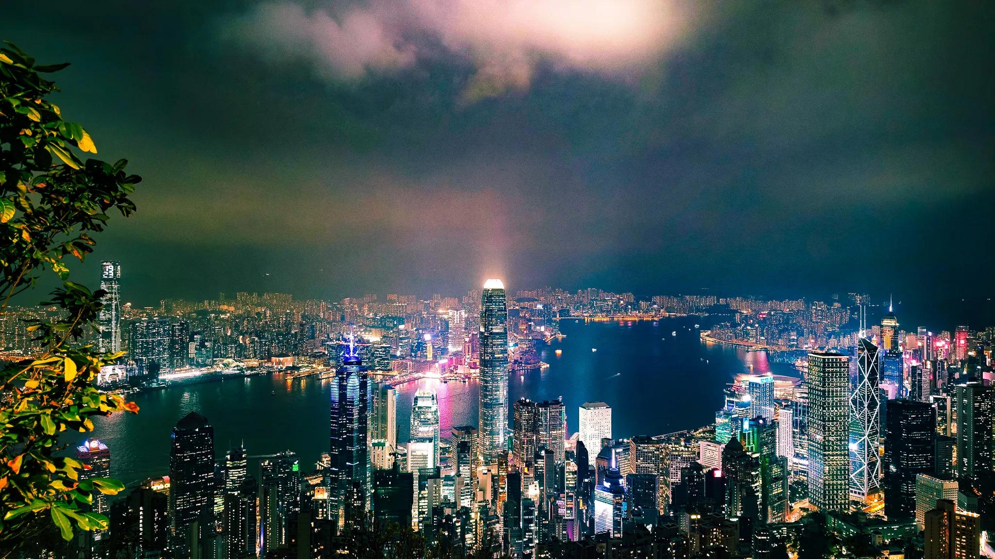Panoramic night view from Victoria Peak featuring IFC tower, Victoria Harbour and Kowloon skyline with pink cloud glow