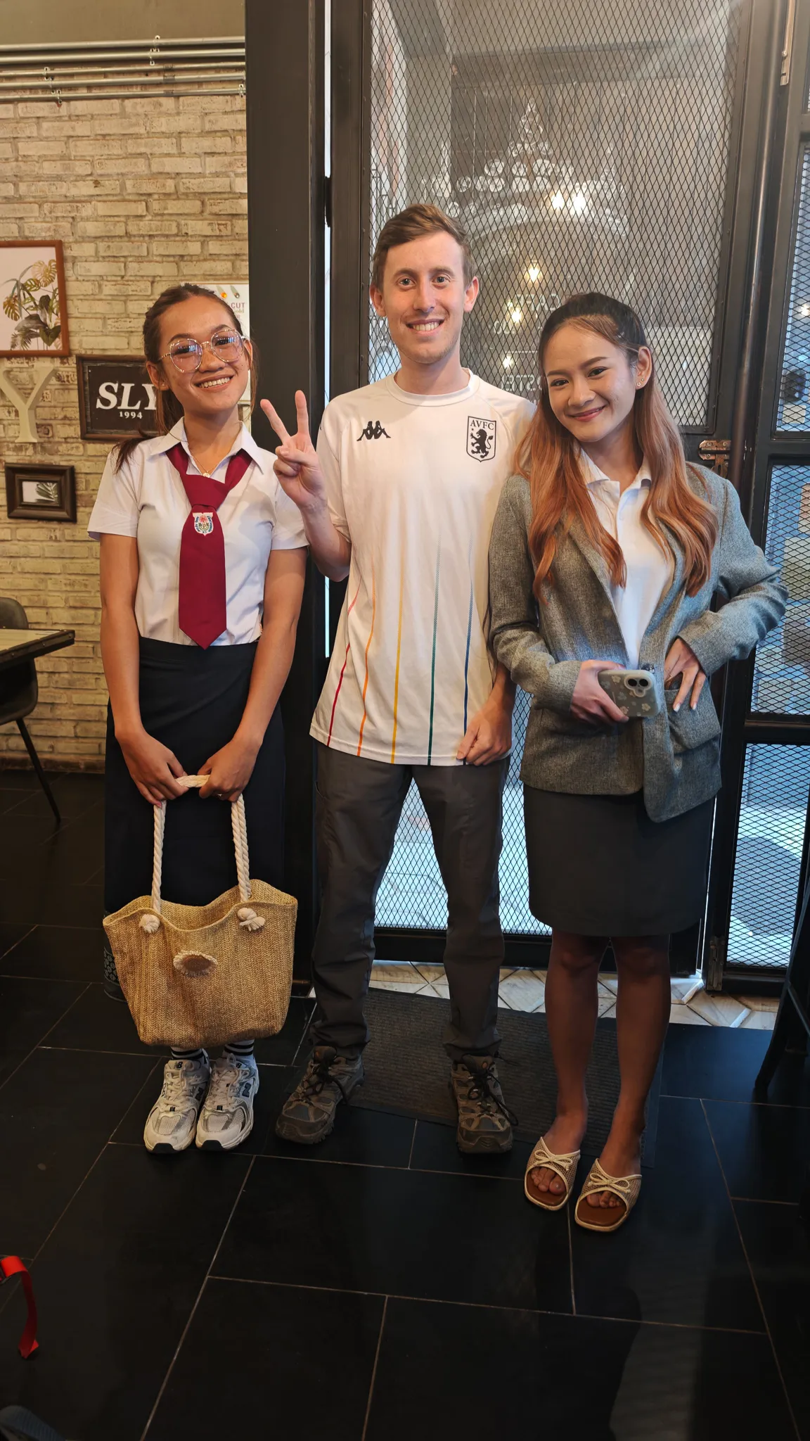 Goodbye photo with a Lao friend giving peace signs at a cafe in Vientiane before the overnight train to Bangkok