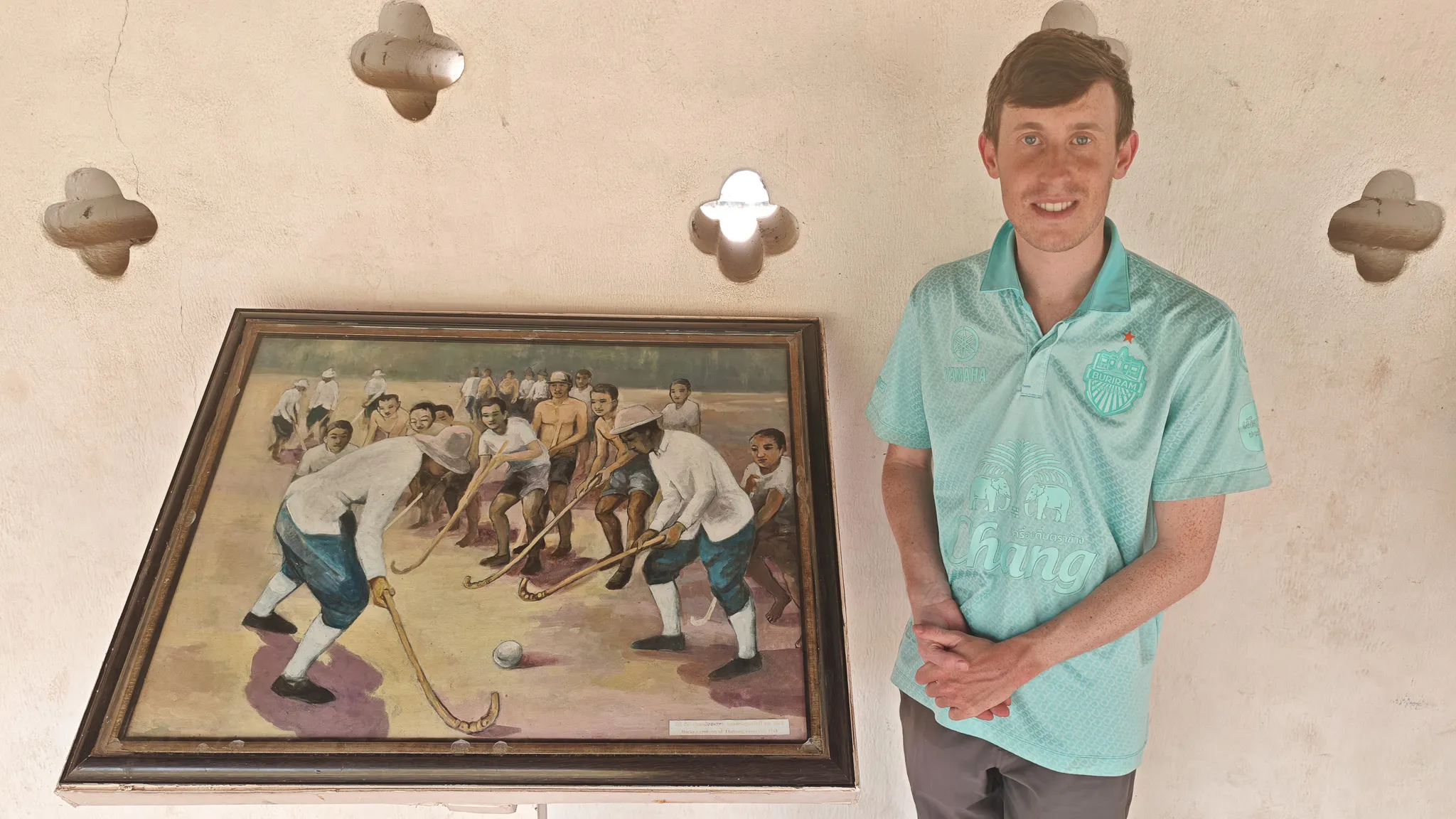 Posing next to a historical hockey painting inside the Pha That Luang temple wearing a Chang beer shirt