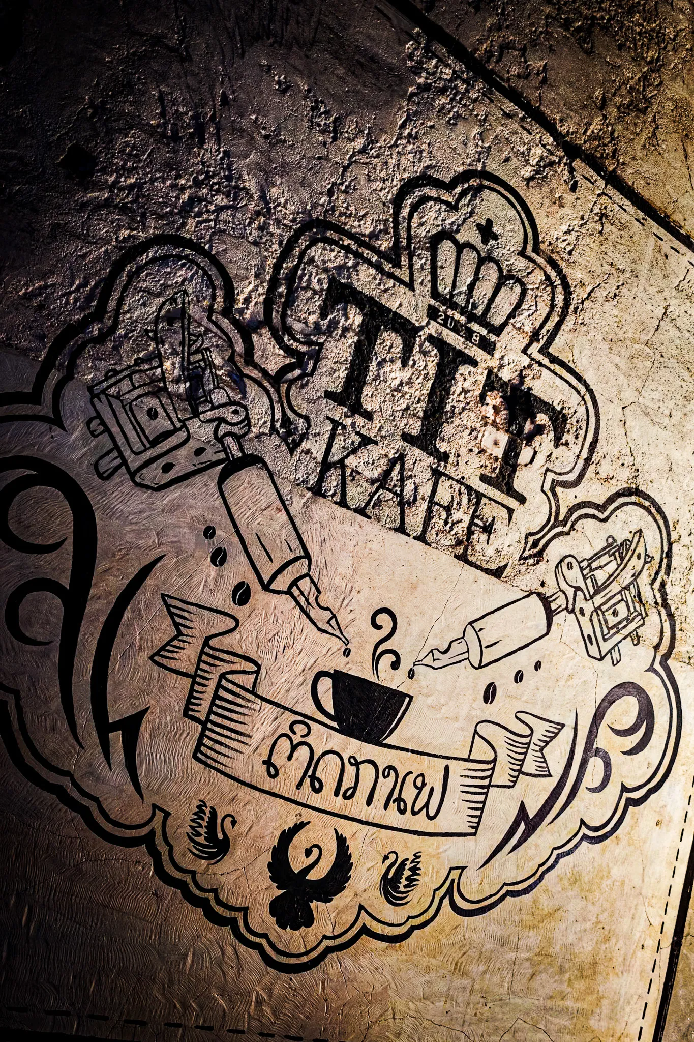Artistic wall mural sign for Tip Kafe featuring tattoo-style lettering in Vientiane