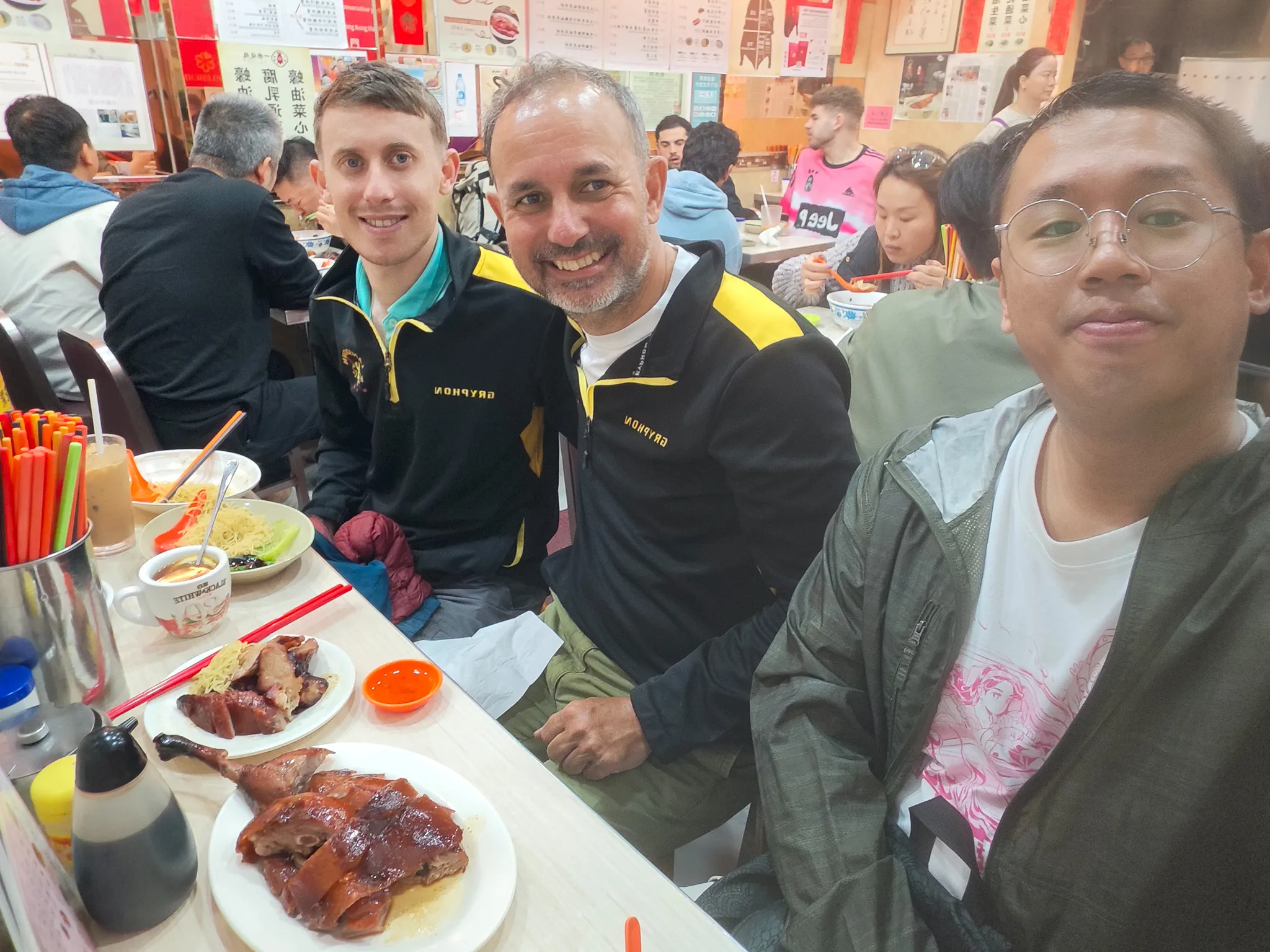 Selfie with friends at Yat Lok roasted goose restaurant in Kowloon with plates of roast goose on the table